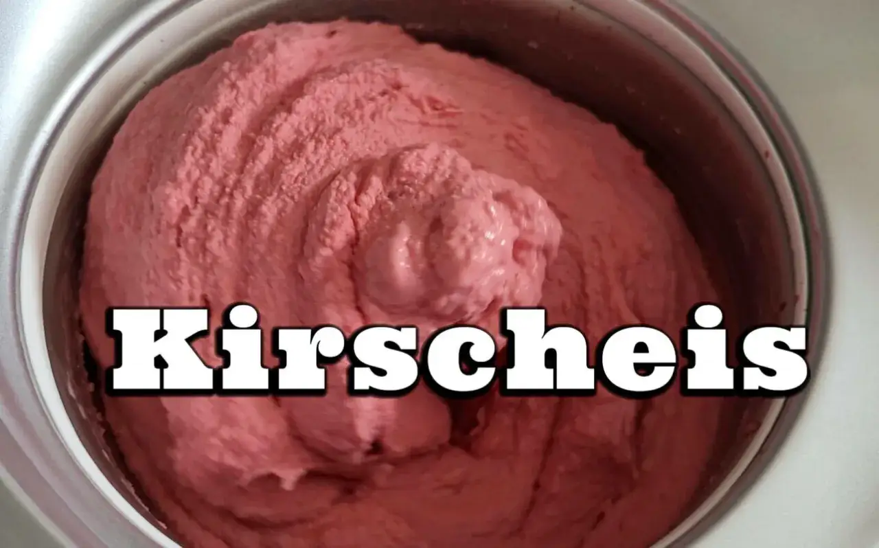 Frisch zubereitetes Kirscheis in einer Eismaschine. Die cremige Konsistenz und die leuchtend rosa Farbe versprechen puren Genuss.