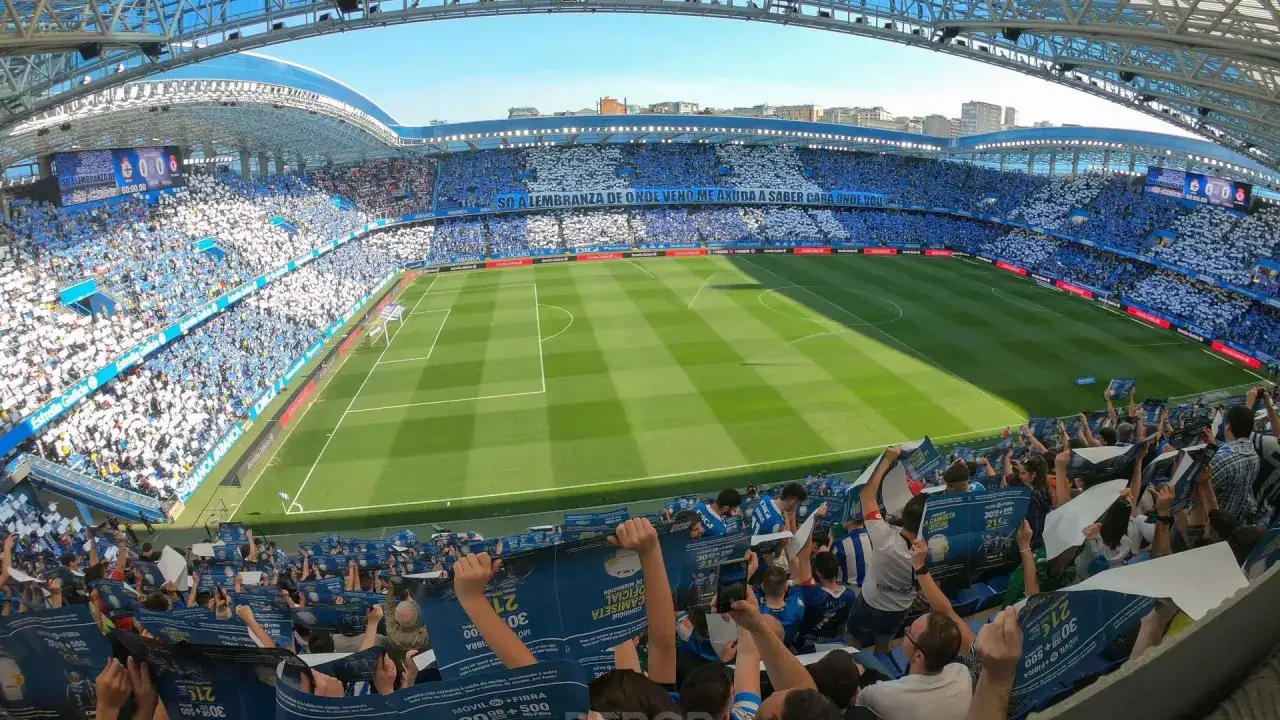 Aficionados del Deportivo de la Coru&ntilde;a animan en un partido contra el FC Barcelona. El estadio se ti&ntilde;e de azul y blanco.