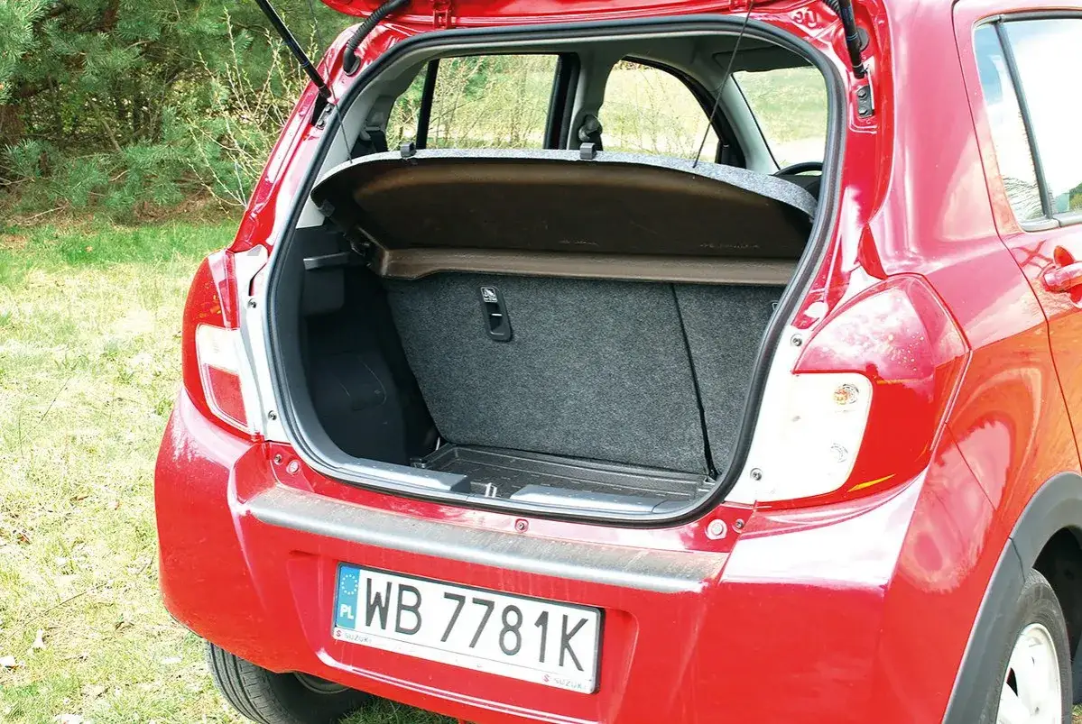 Czerwony Suzuki Celerio z otwartym bagażnikiem, gotowy na podróż.