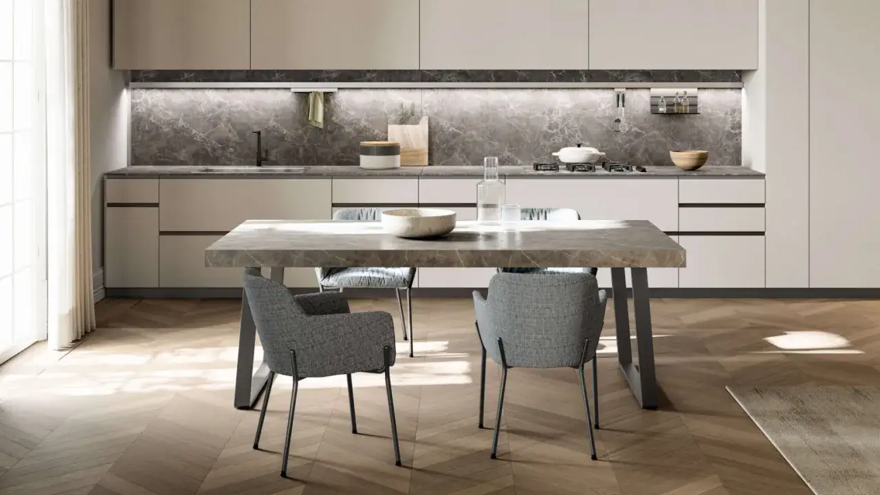 Tavolo da pranzo moderno con piano in marmo e sedie grigie. L'altezza del tavolo da pranzo &egrave; perfetta per la zona cucina.