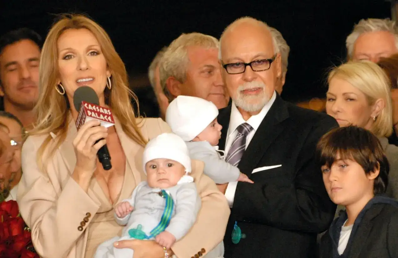 Celine Dion z dziećmi, w tym bliźniętami, na rękach. Obok niej mąż René Angélil i starszy syn.