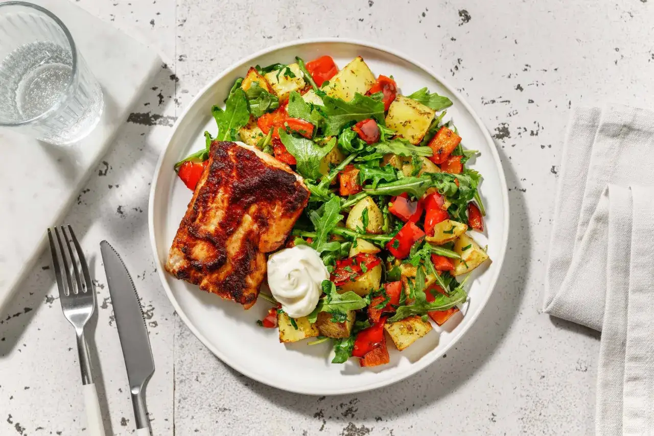 En tallrik med kryddig lax, rostade potatisar, paprika och ruccola. Ett perfekt val f&ouml;r en glutenfri kost.