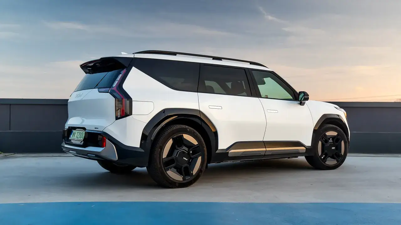 Biały Kia EV9 z czarnymi detalami i futurystycznymi felgami stoi na parkingu.