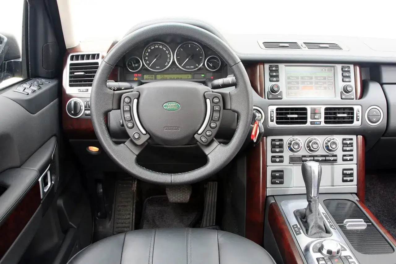 Wnętrze Range Rover L322 z kierownicą, deską rozdzielczą i ekranem nawigacji.