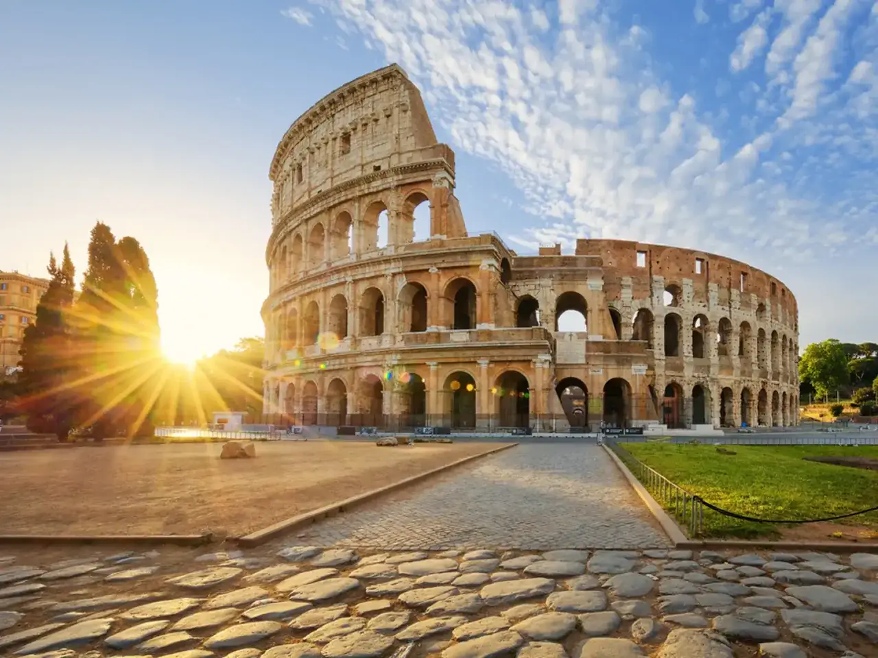 Colosseum i Rom, en ikonisk sevärdhet som man absolut inte får missa i Rom. Solen strålar över den antika amfiteatern.