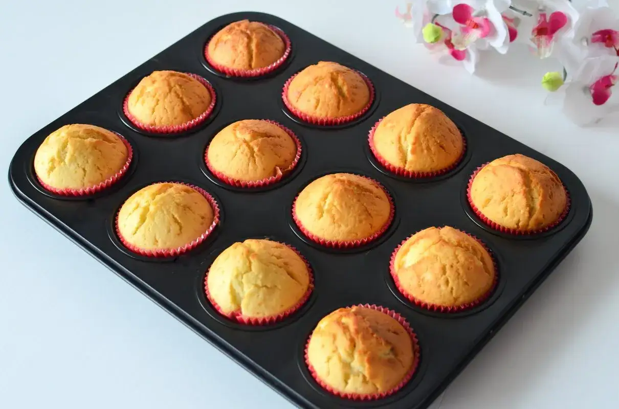 Puszyste muffinki w czerwonych papilotkach, gotowe do podania. Idealny przepis na wilgotne i puszyste muffinki.