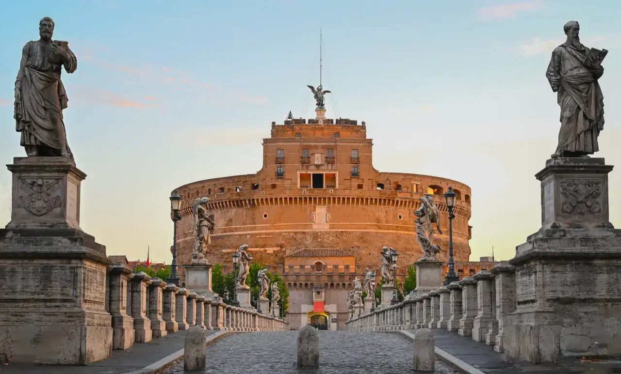 Pont Saint-Ange à Rome, avec ses statues d'anges et le château Saint-Ange en arrière-plan, sous un ciel doux.