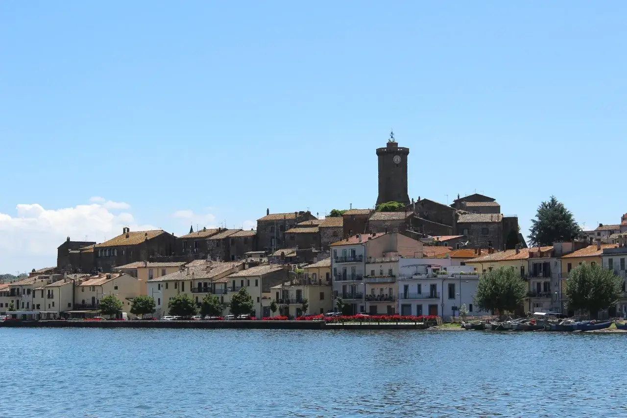 Marta, una veduta del borgo di Marta sul lago di Bolsena, con le case colorate e la torre medievale.
