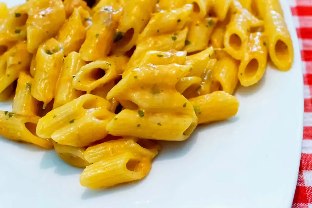 En krämig pasta milanese med penne, täckt i en gyllene sås med små gröna örter.