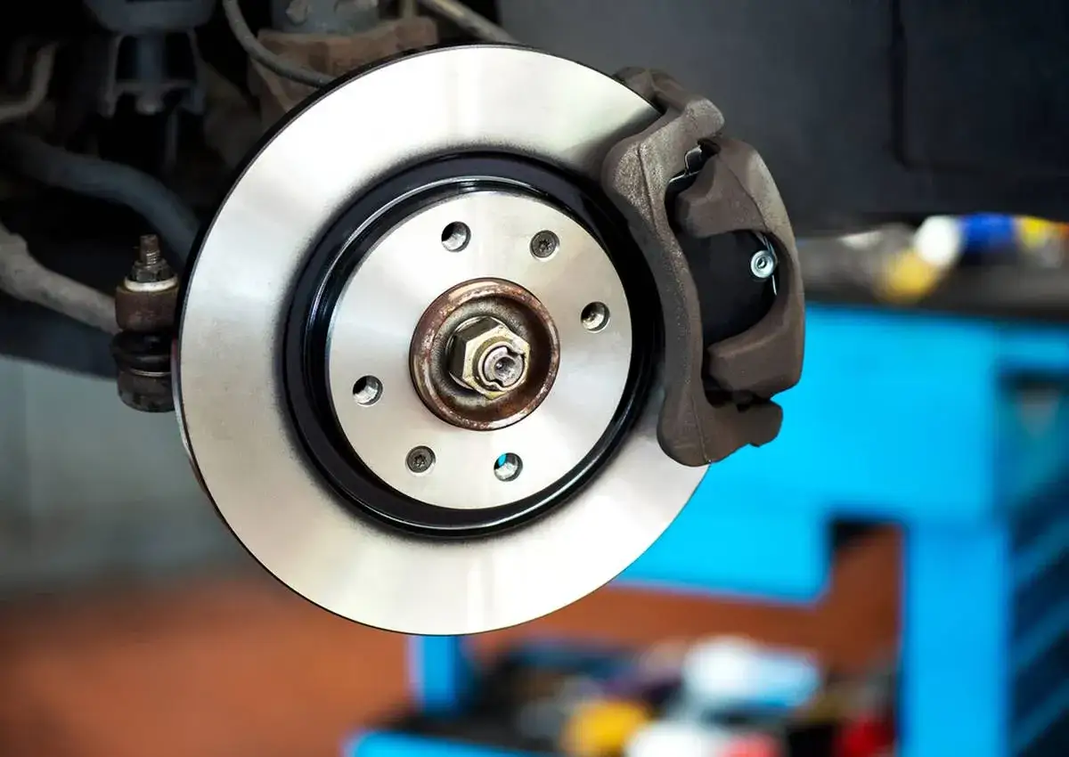 Gros plan sur un disque de frein et son étrier. Ce frein qui siffle pourrait indiquer un besoin de maintenance.