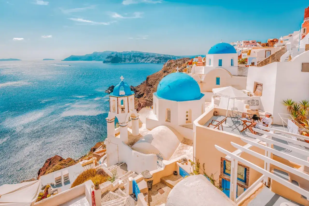 Santorini, jedno z najpiękniejszych wysp greckich, z białymi domkami i niebieskimi kopułami kościołów nad lazurowym morzem.
