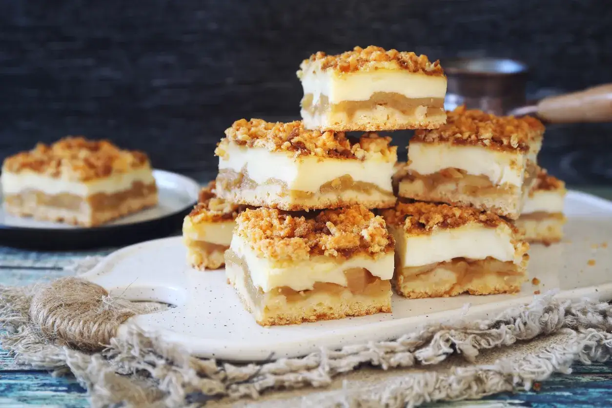 Pyszny strudel z jabłkami, ułożony w stosik, z chrupiącą kruszonką i kremową warstwą.