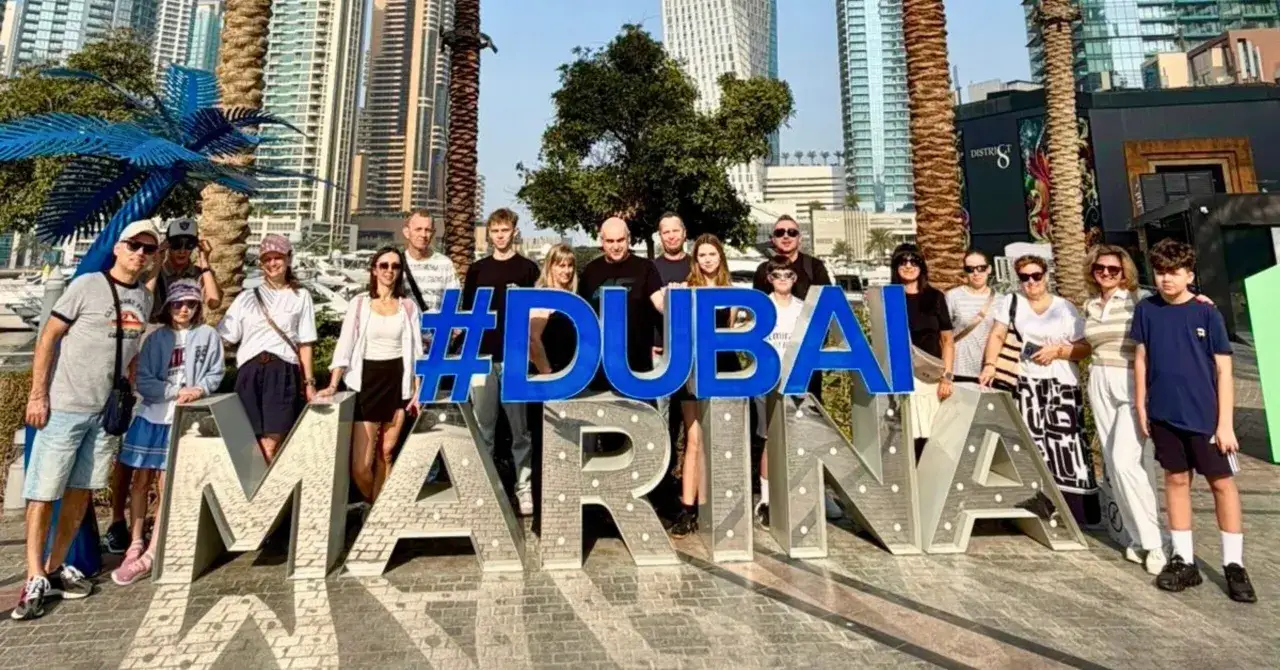Rodzina pozuje przy napisie #DUBAI MARINA. Wiza do Dubaju załatwiona, czas na zwiedzanie!
