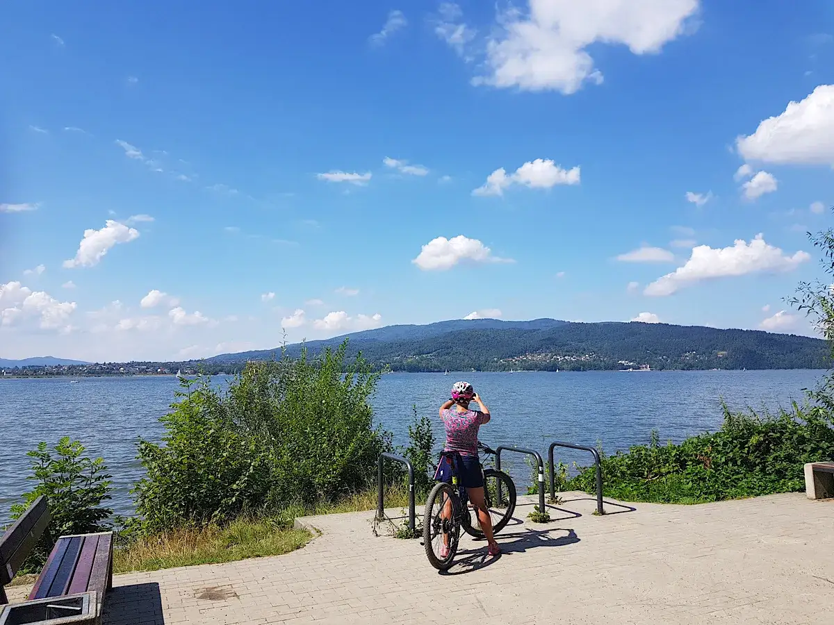 Kobieta z rowerem podziwia widok na Jezioro Żywieckie. Idealne miejsce na odkrywanie tras rowerowych Żywiec.