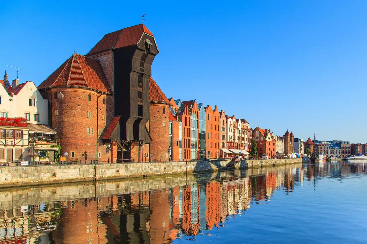 Gdańsk co zwiedzić? Nad Motławą widać Żuraw, kamieniczki i nowoczesną architekturę. Idealne miejsce na spacer i podziwianie widok&oacute;w.