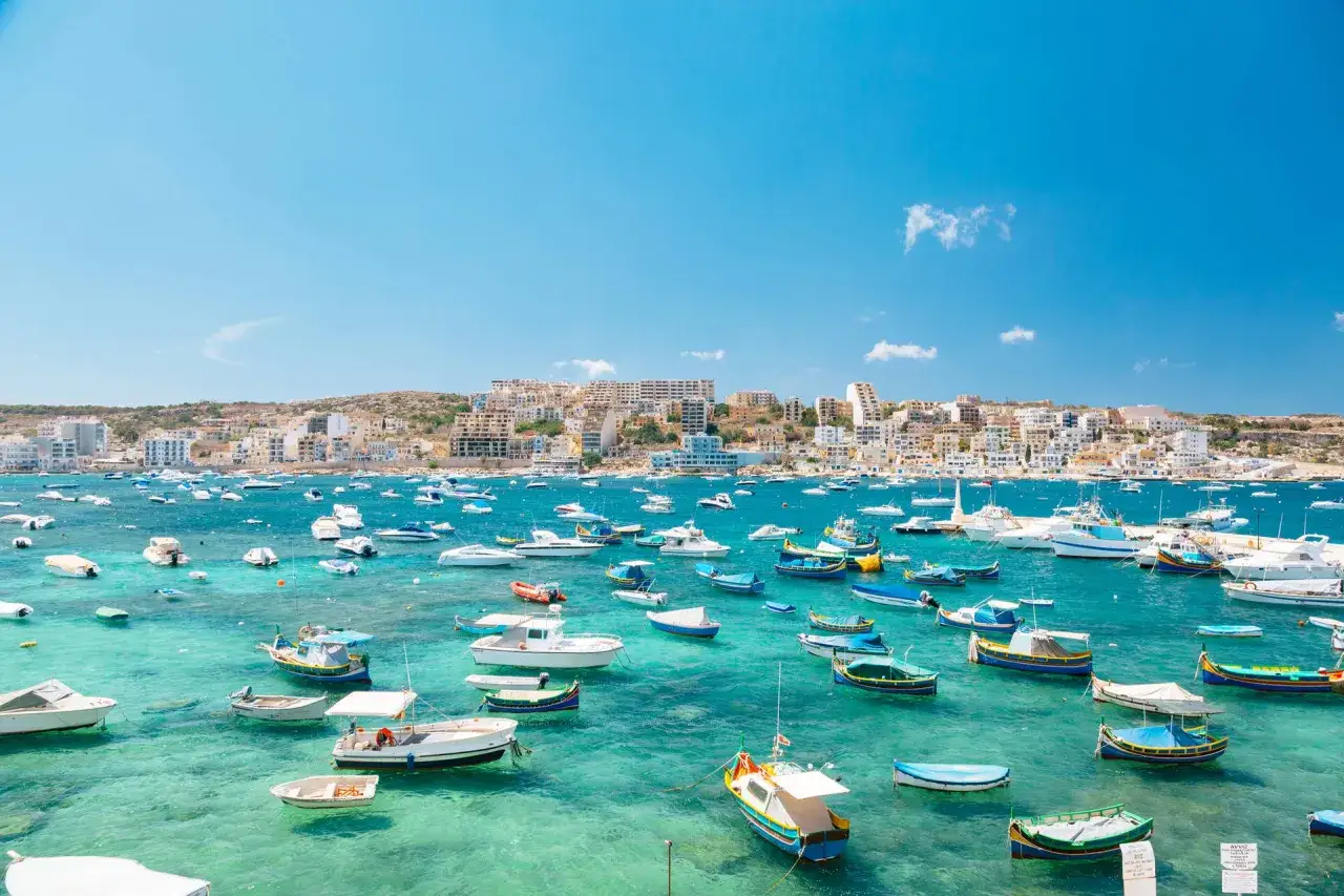 Malta, marzec. Słoneczna pogoda, turkusowa woda i mnóstwo łodzi w zatoce.