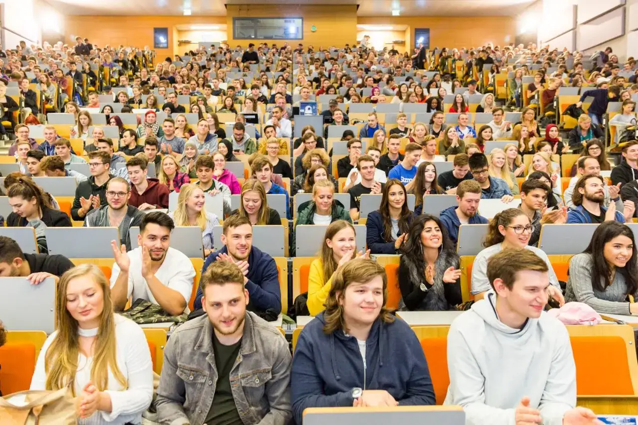 Gro&szlig;er H&ouml;rsaal am campus duisburg, gef&uuml;llt mit Studierenden, die gespannt zuh&ouml;ren und applaudieren.