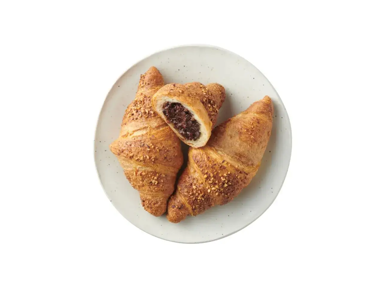 Trzy chrupiące croissanty z nadzieniem orzechowym z Lidla. Jeden przekrojony ukazuje bogate, ciemne nadzienie.