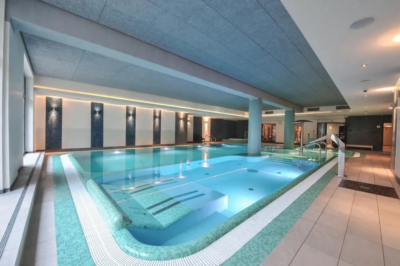 Elegancki hotel młyn z basenem, gdzie błękitna woda zaprasza do relaksu.