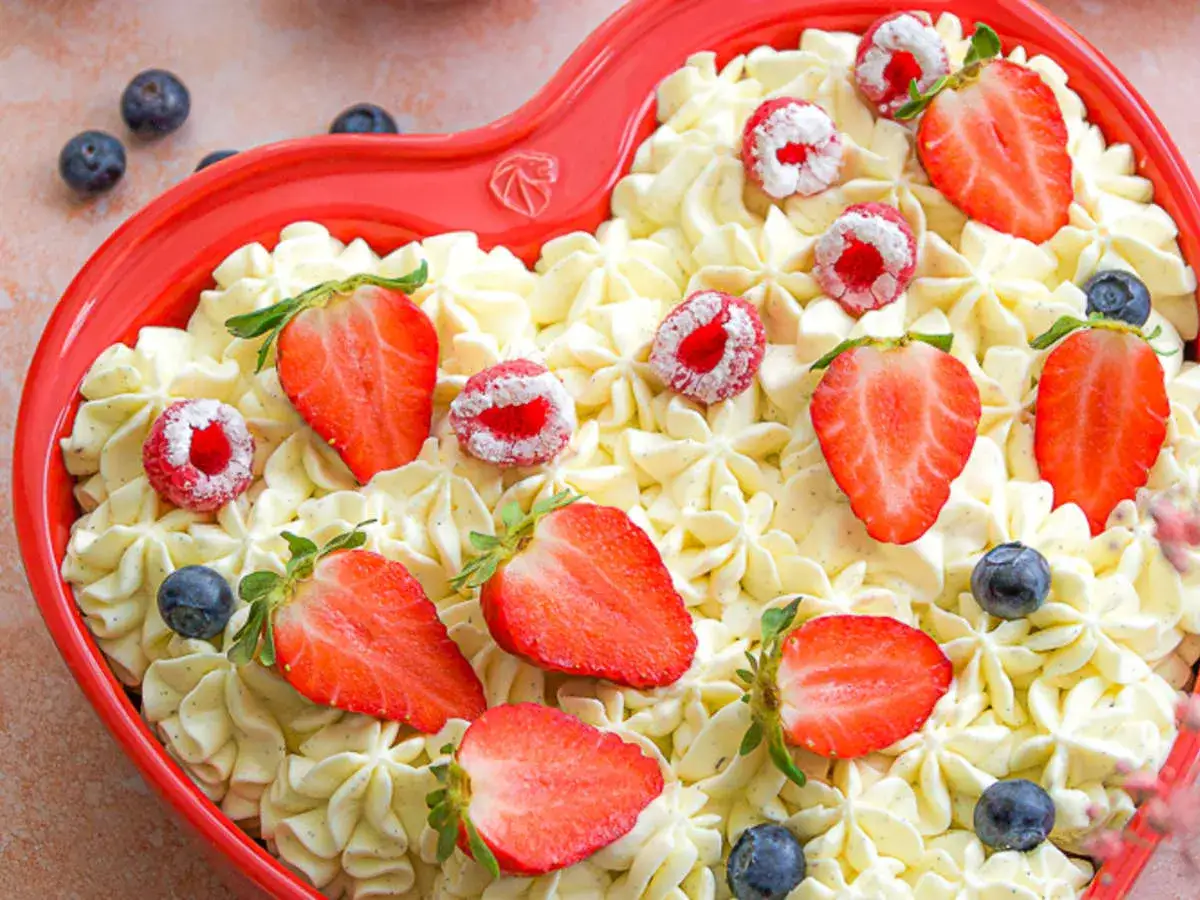Un délicieux fourrage pour gâteau en forme de cœur, garni de fraises, framboises et myrtilles. Un délice visuel et gustatif.
