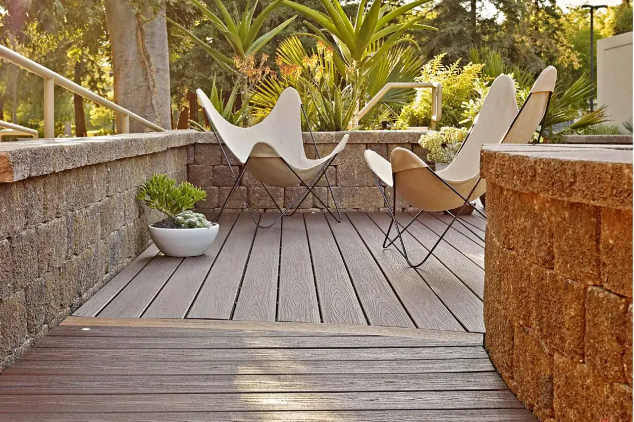 Zwei Butterfly-St&uuml;hle auf einer Holzterrasse, umgeben von Steinmauern und &uuml;ppiger Vegetation. Tolle garten terrasse ideen f&uuml;r entspannte Nachmittage.