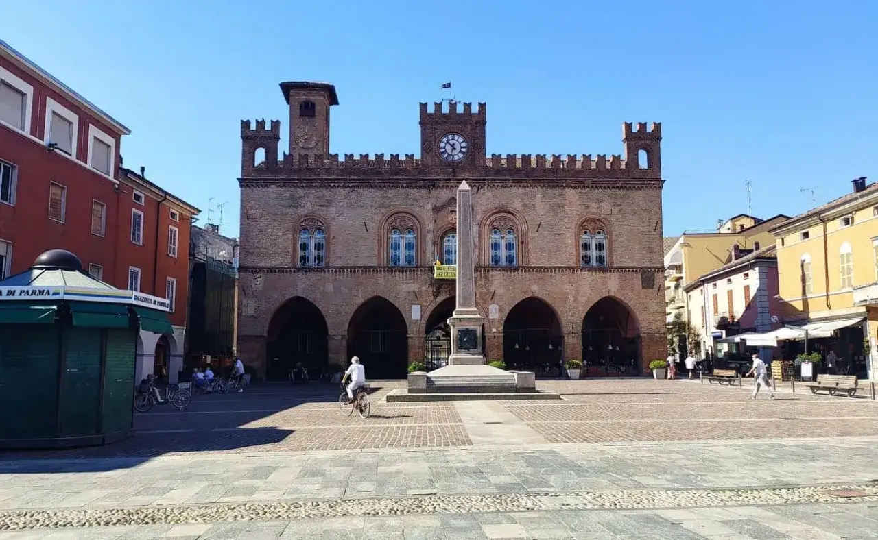 Piazza del Duomo a Fidenza: cosa vedere? Il Palazzo Comunale con la torre dell'orologio e l'obelisco centrale dominano la piazza.
