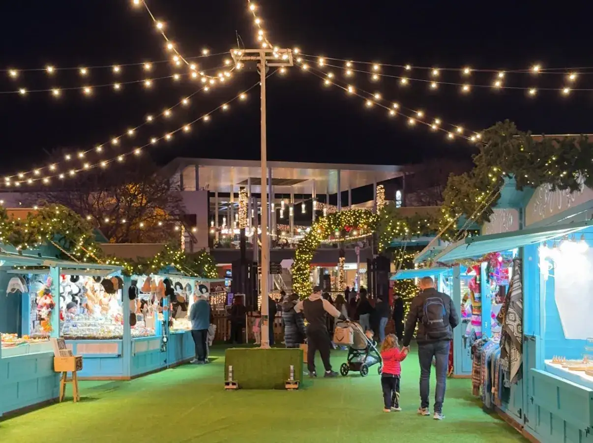 Mercado navideño con luces y puestos. Ideal para tus planes para el puente de diciembre.