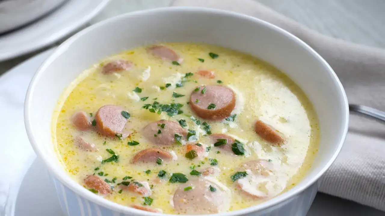 Cremige Kartoffelsuppe mit Würstchenscheiben und Petersilie. Ein einfaches und leckeres Kartoffelsuppe Rezept für kalte Tage.