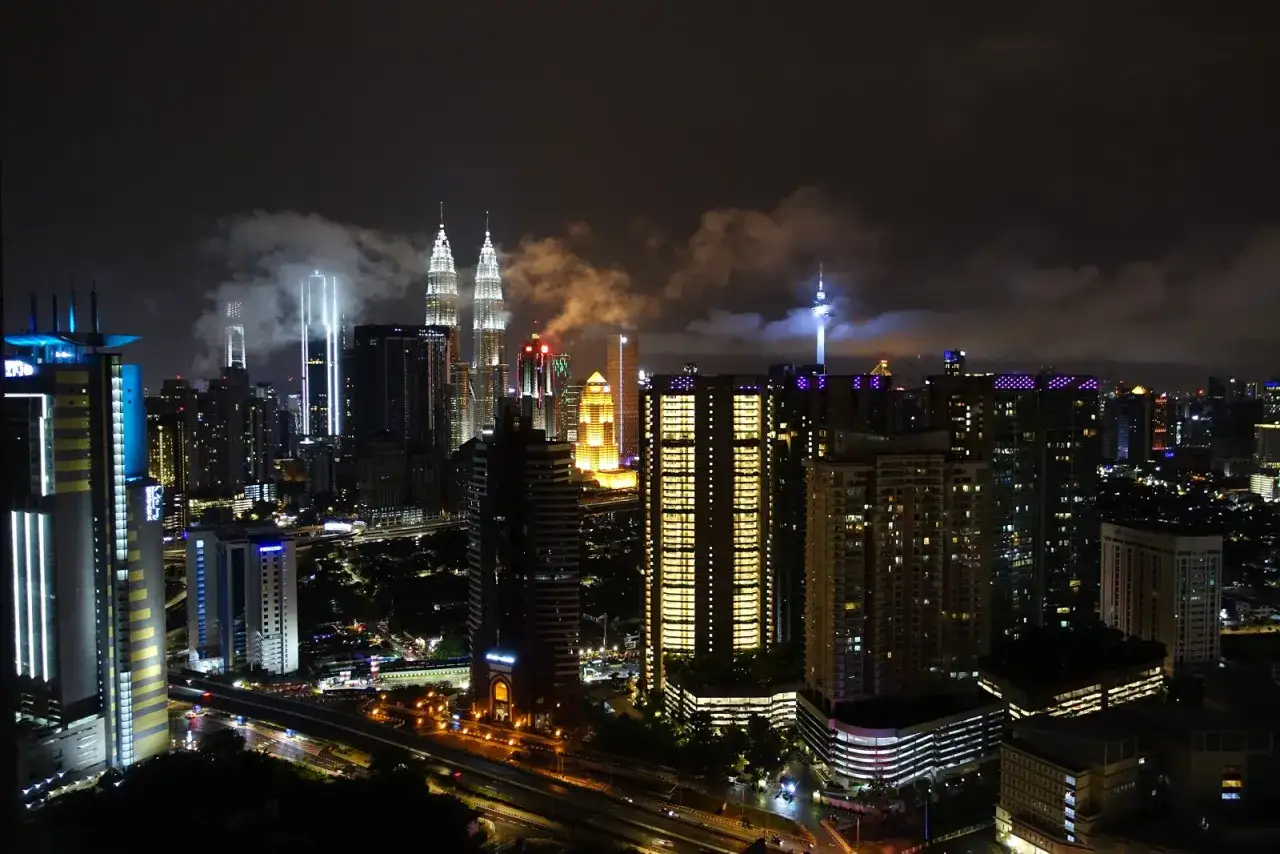 Nocny widok na nowoczesne drapacze chmur w stolicy Malezji, Kuala Lumpur, z charakterystycznymi wieżami Petronas.