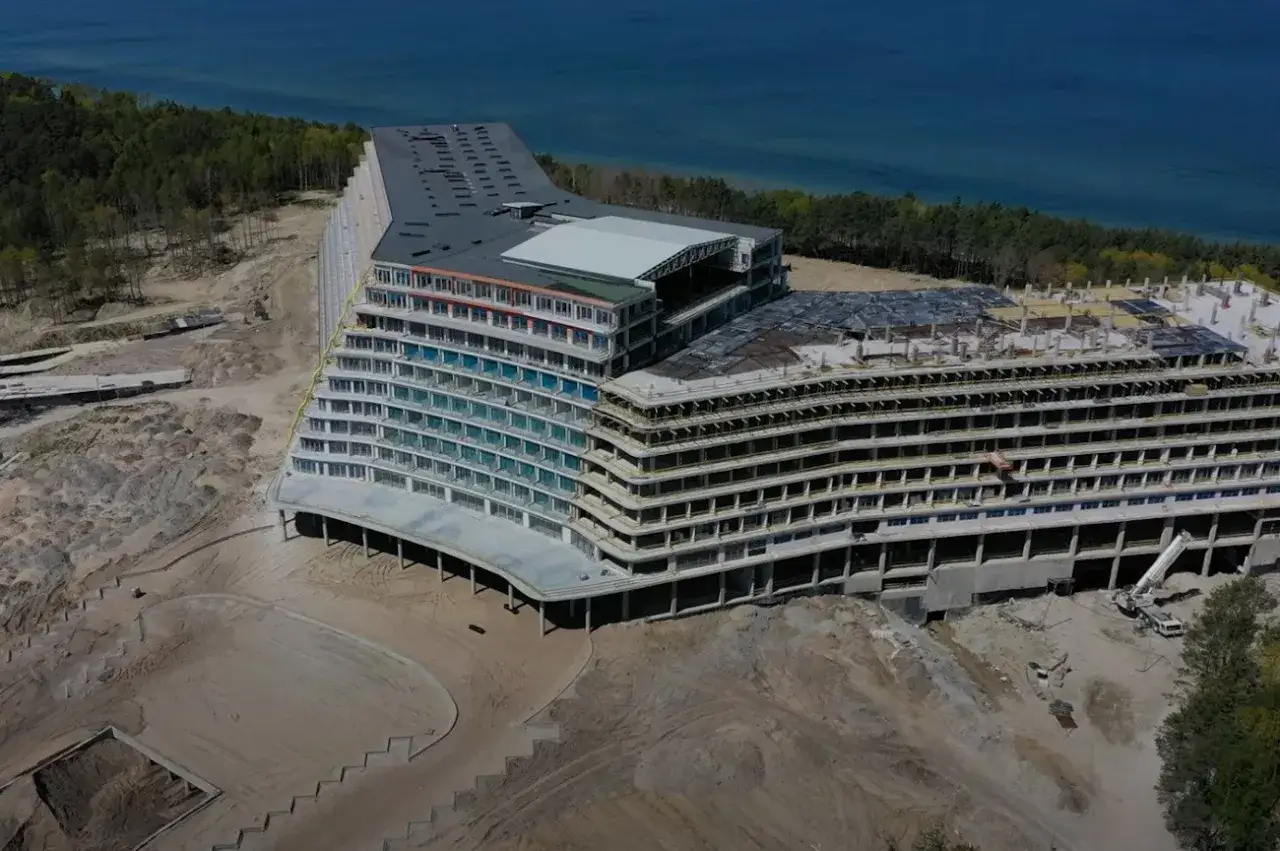 Ogromny hotel nad morzem w budowie, z widokiem na las i błękitną wodę. Powstaje największy hotel nad morzem.