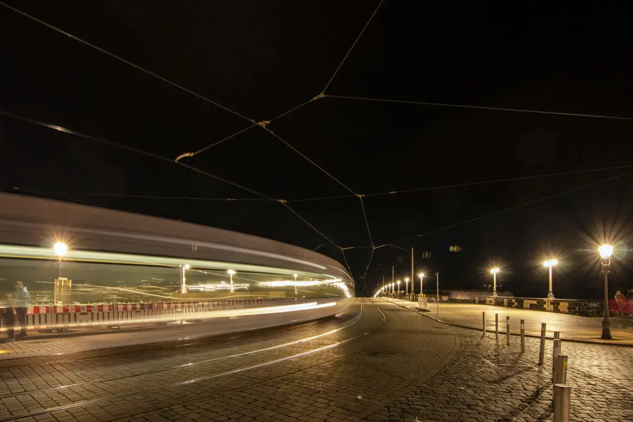 Nocny tramwaj w Dreźnie. Czy Drezno jest bezpieczne? Miasto nocą, oświetlone latarniami, z ruchem ulicznym.