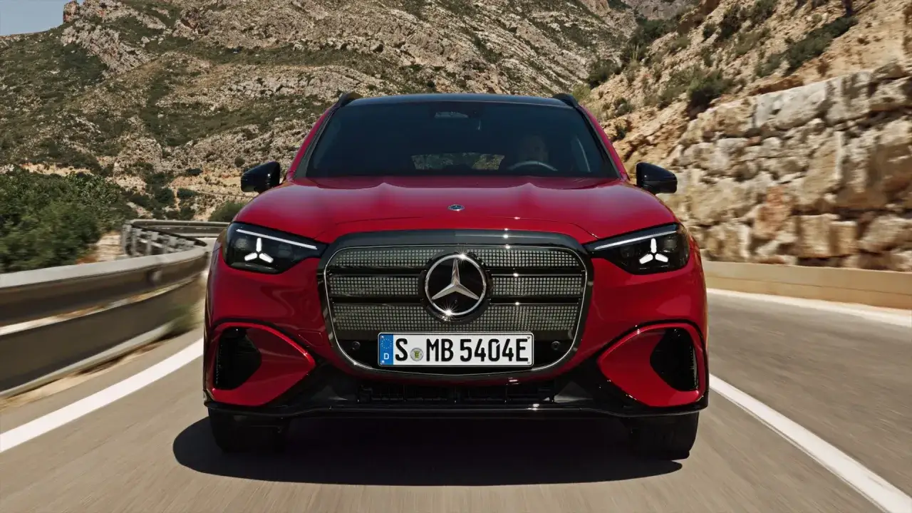 Czerwony Mercedes EQB jedzie krętą drogą w górach.