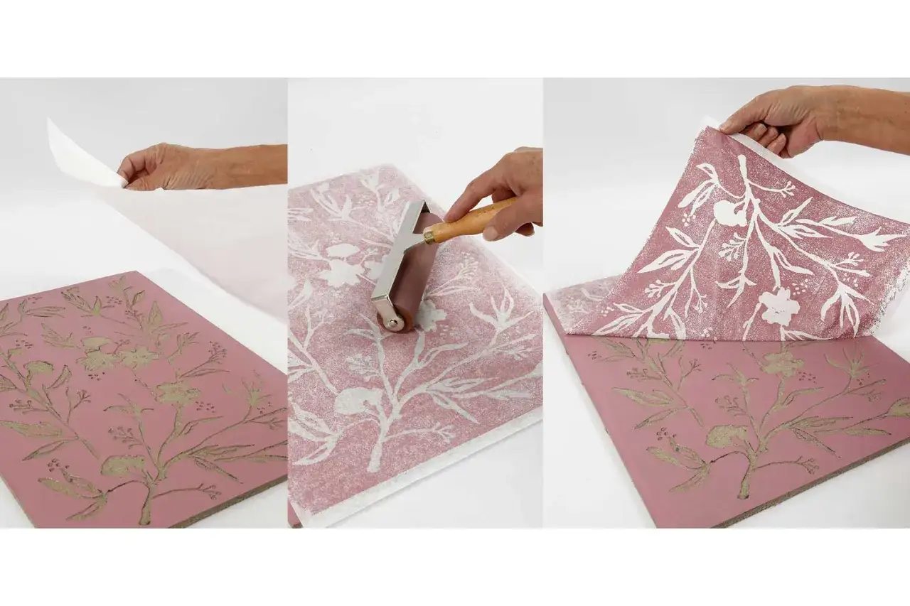 Application d'un motif floral sur un papier linogravure à l'aide d'un rouleau. Le résultat est un papier décoratif aux teintes douces.