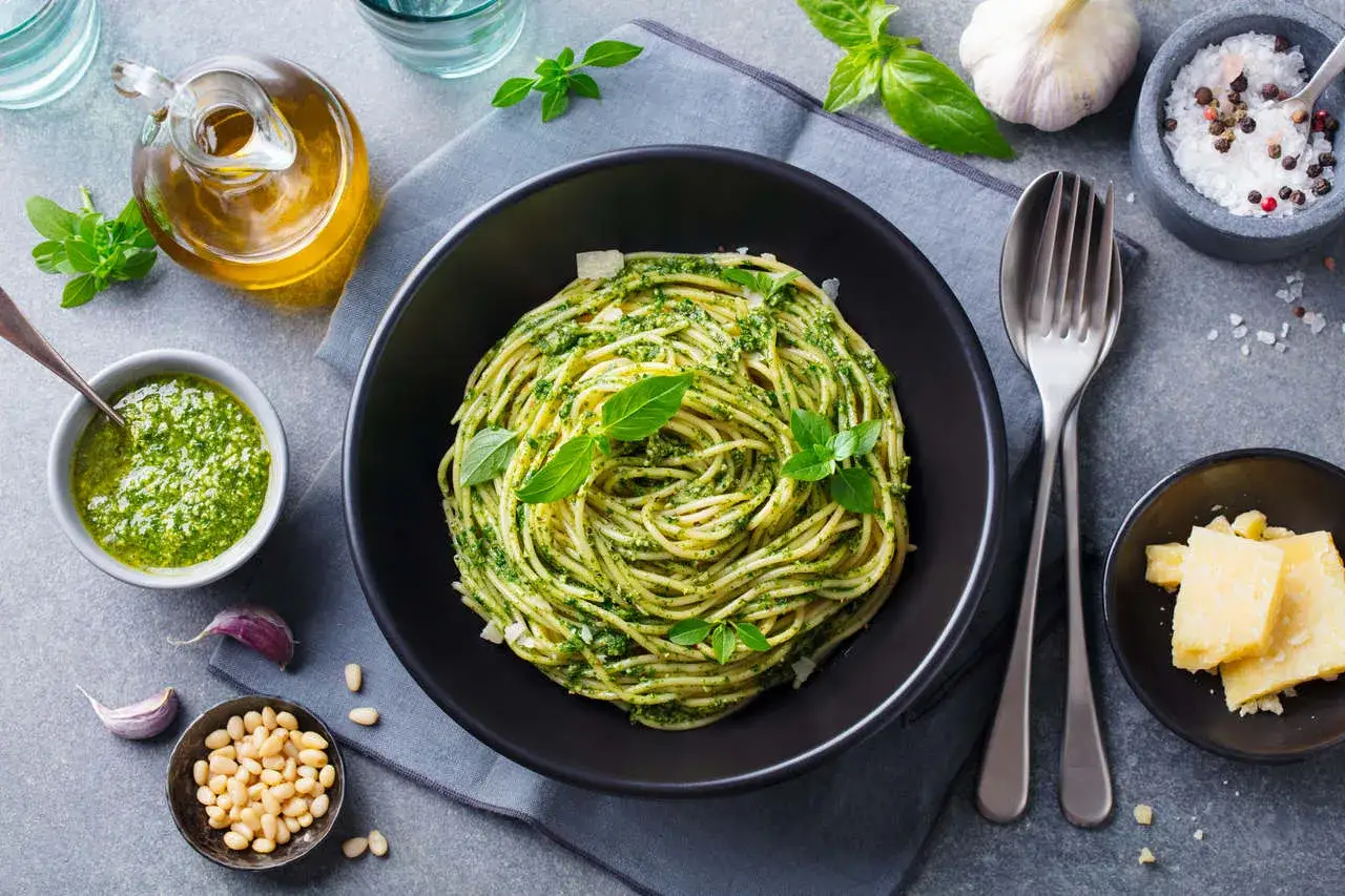 Pyszne spaghetti z pesto, idealne co na obiad zamiast mięsa. Podane z bazylią, orzeszkami pinii i parmezanem.