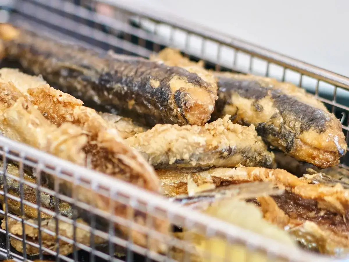 Fritura de pescado reci&eacute;n hecha en una cesta met&aacute;lica. Crujientes y dorados, listos para disfrutar.