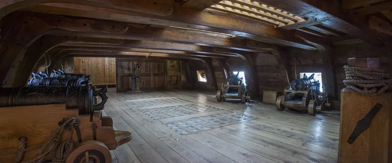 Interni di nave vasa con cannoni in legno e cordame.