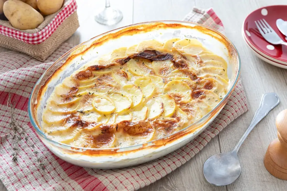 Gratin de pommes de terre cr&eacute;meux, une recette r&eacute;confortante. Des fines tranches de pomme de terre dor&eacute;es au four, parsem&eacute;es d'herbes.