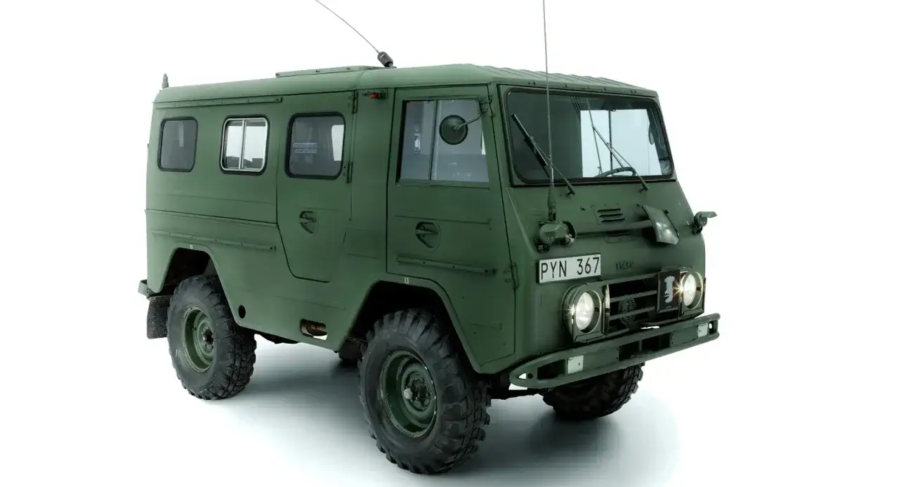 Gr&ouml;n milit&auml;rbil, en Volvo Valp, med stora grovm&ouml;nstrade d&auml;ck och antenn.