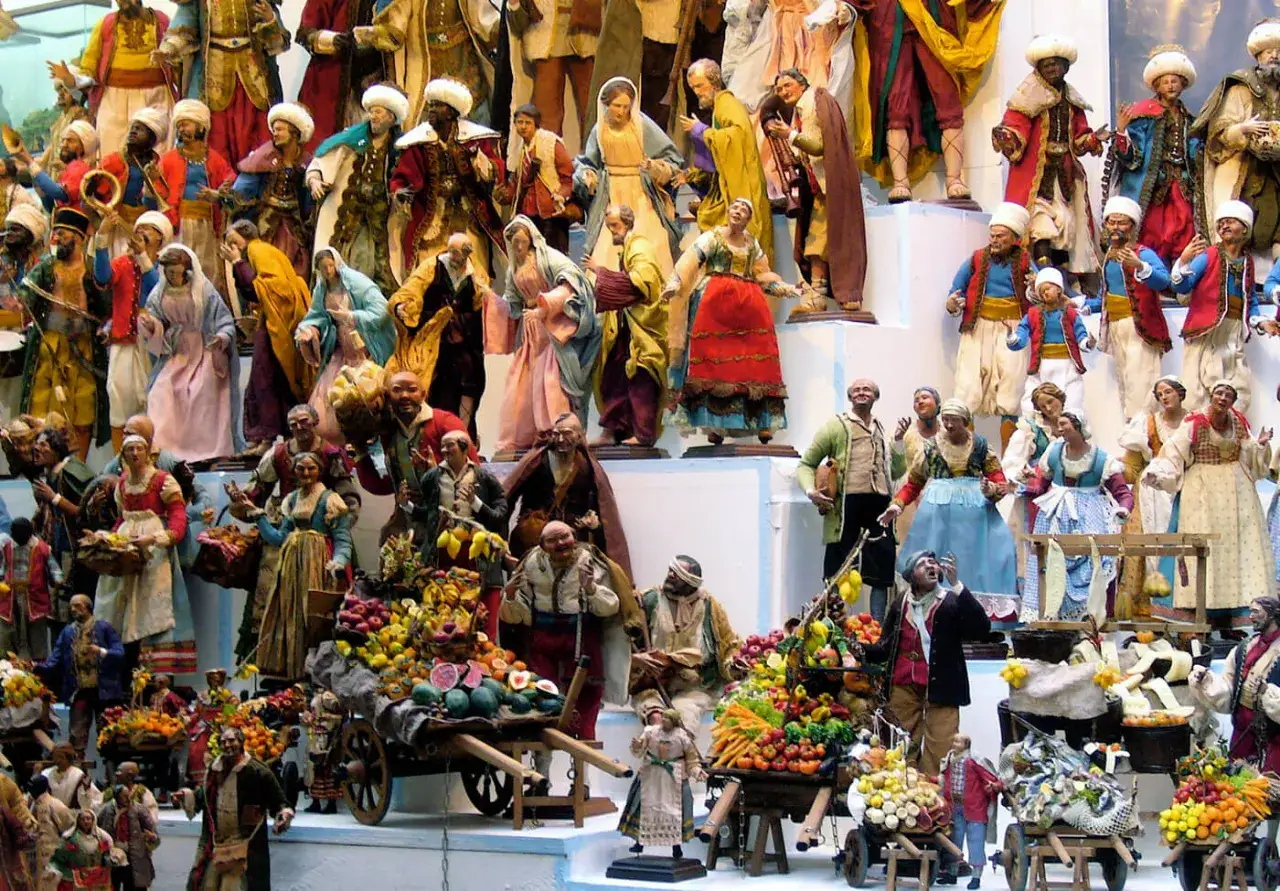 A vibrant nativity scene in Naples in December, with detailed figures of merchants selling fruit and vegetables.