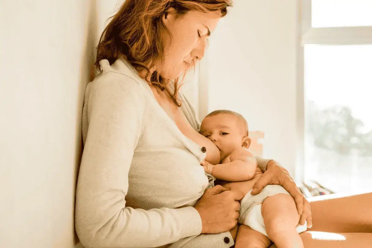 Mutter stillt Baby. Manche fragen sich, ob man zu viel stillen kann, aber hier ist es ein Moment der Nähe.