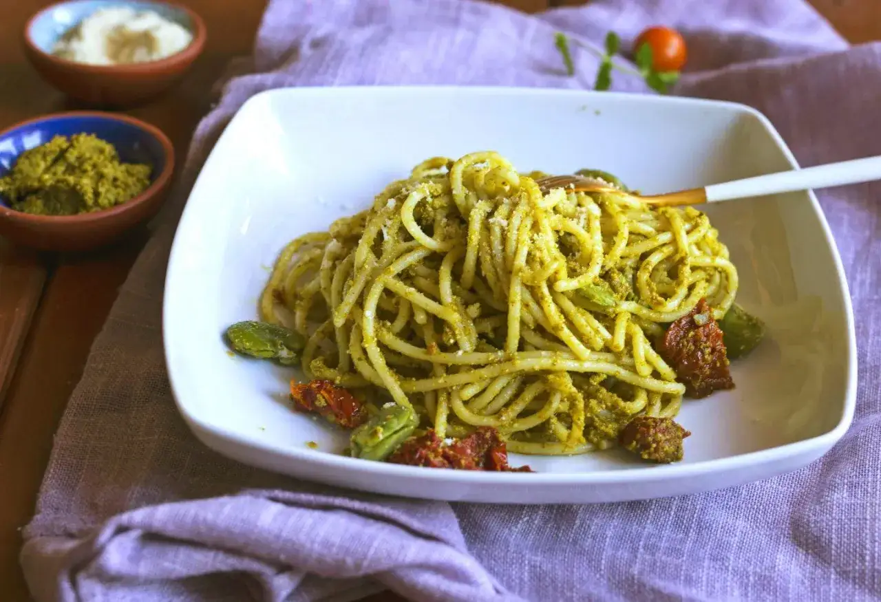 Spaghetti z aromatycznym, włoskim sosem na bazie bazylii, podane z fasolką i suszonymi pomidorami.