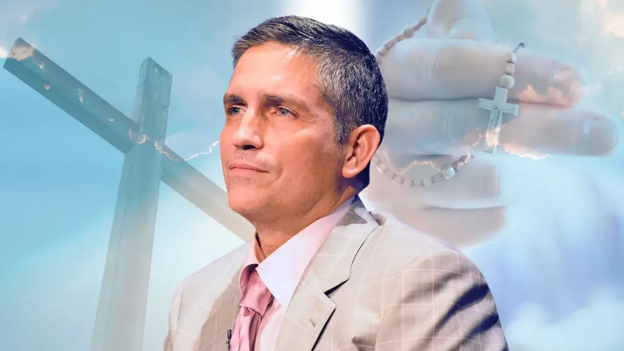 Jim Caviezel nawrócenie. Aktor w garniturze, z różańcem w dłoni, na tle krzyża i nieba.