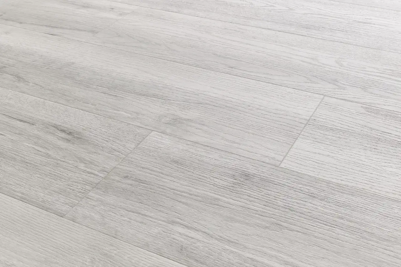 Pavimenti SPC cosa sono? Un pavimento in laminato grigio chiaro con venature di legno, resistente e moderno.