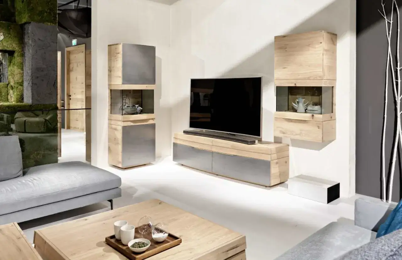 Un meuble TV DIY moderne en bois et métal, avec des étagères ouvertes et fermées, complété par une table basse en bois.
