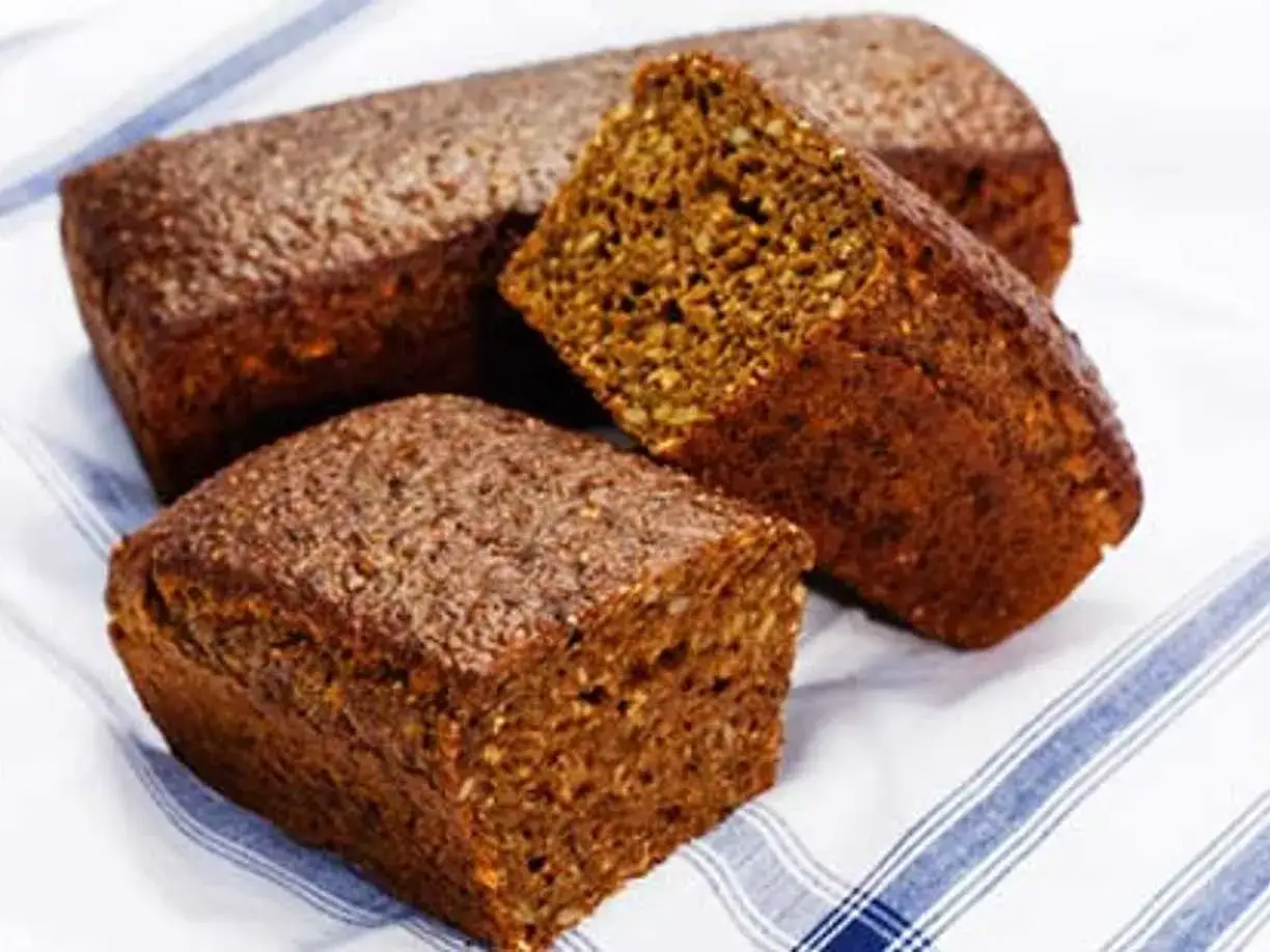 Tre m&ouml;rka, saftiga r&aring;gbr&ouml;d ligger p&aring; en randig duk. Perfekt f&ouml;r en &auml;kta dansk mat-upplevelse.