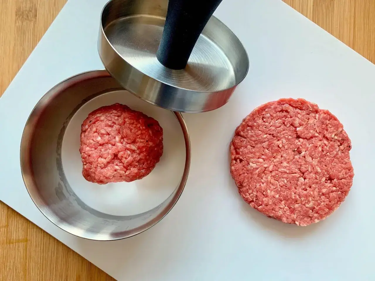 Burgerpresse und Hackfleisch f&uuml;r den perfekten burger patty selber machen. Ein geformter Patty liegt daneben.