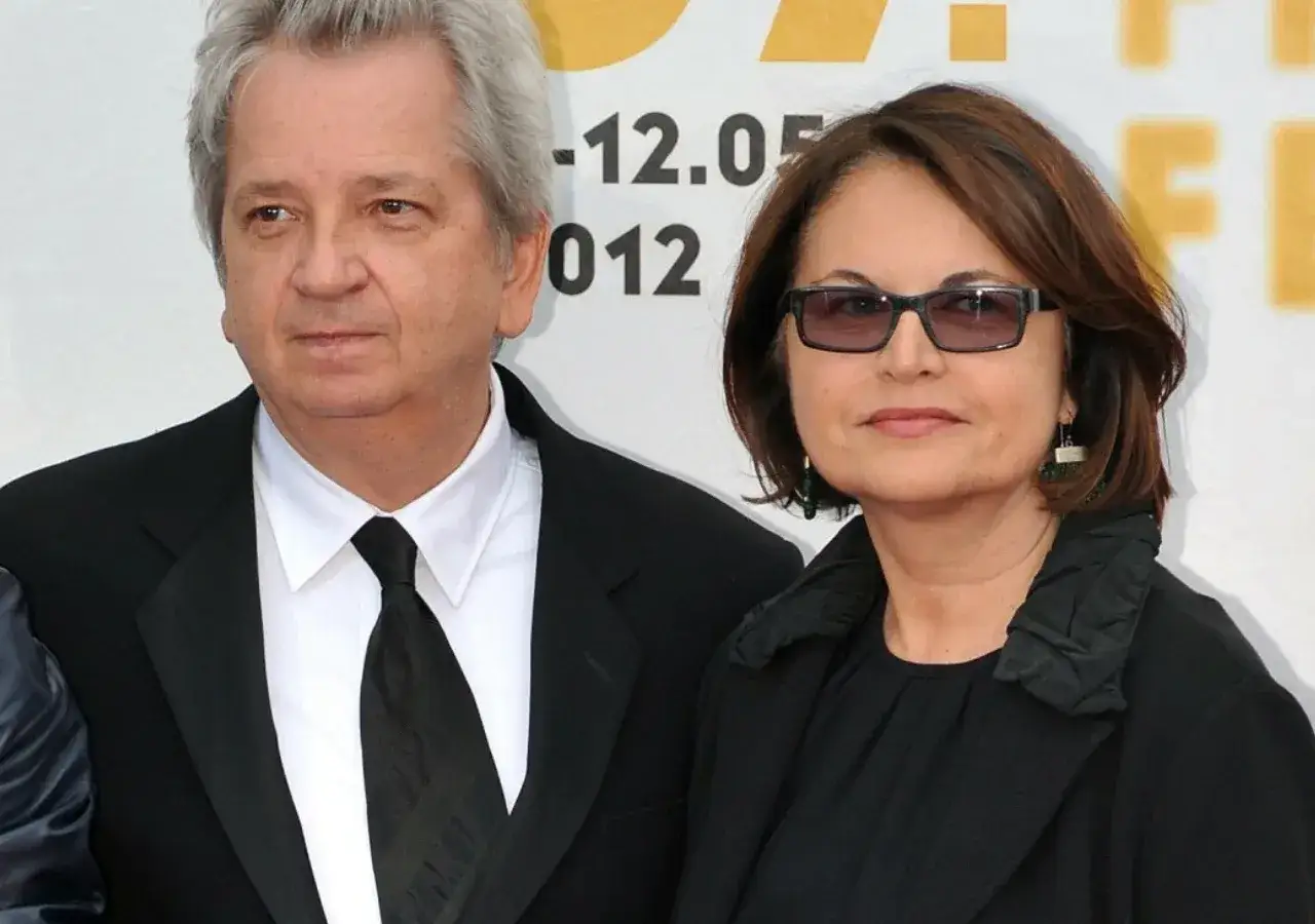 Juliusz Machulski z żoną, w eleganckich strojach, pozują do zdjęcia.