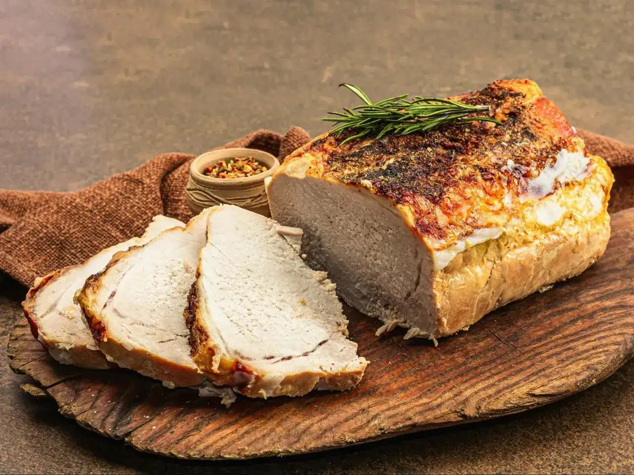 Soczyste, pieczone schab, pokrojone w plastry, z ziołami i przyprawami. Idealne na obiad.