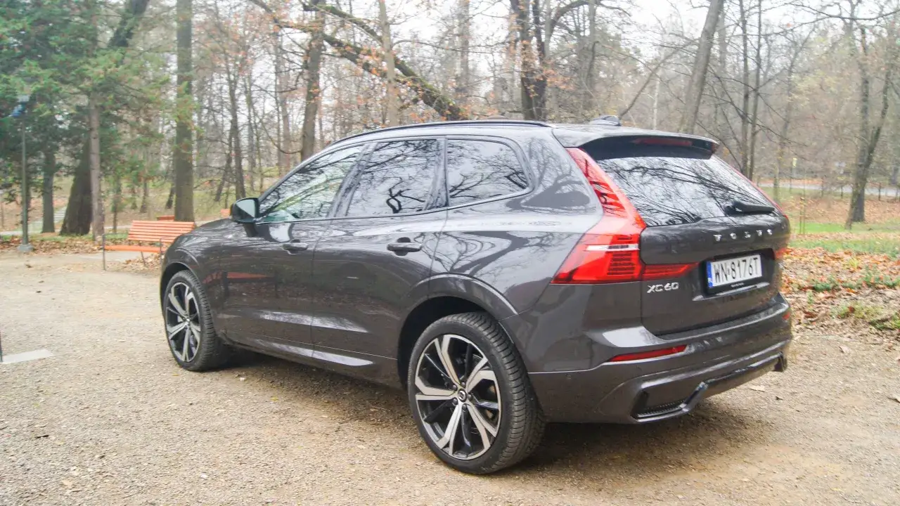 Szare Volvo XC60 na tle jesiennego parku. Zastanawiasz się, ile pali Volvo XC60? Ten model oferuje świetne osiągi i komfort.