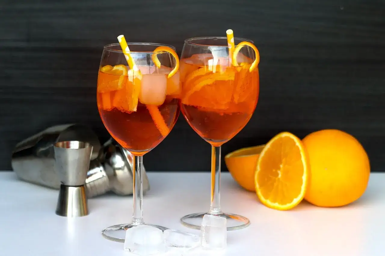 Dwa orzeźwiające drinki Martini Rosato z pomarańczą i lodem, gotowe do degustacji.